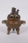 A Chinese bronze two handled censer and cover raised on tripod supports with raised dragon