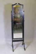 An ebonised frame cheval mirror with brass mounts and bevelled glass, 50 x 52 x 170cm