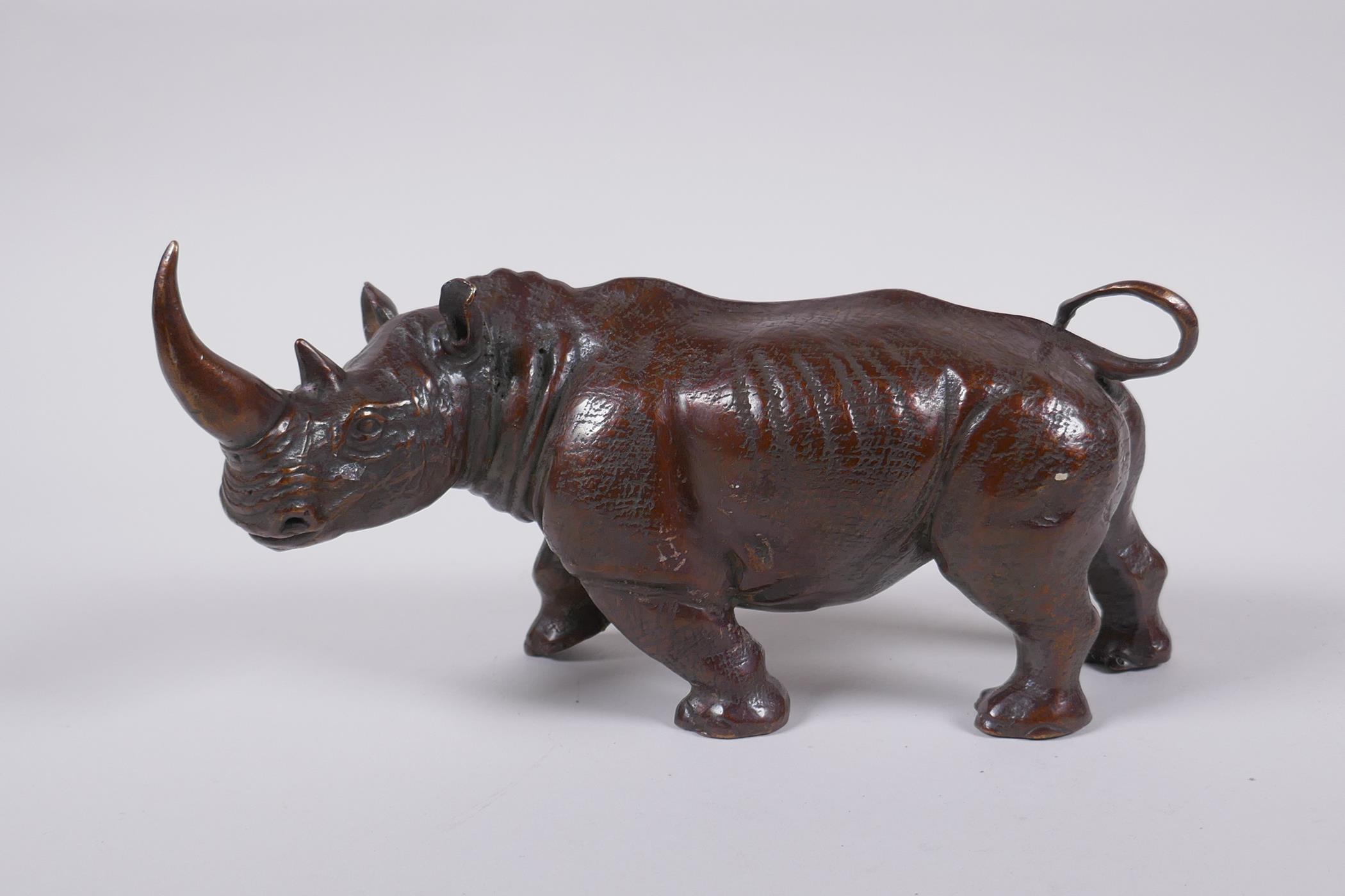 A filled bronze figure of a rhinoceros, 22cm long