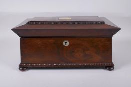 An antique rosewood sarcophagus shaped tea caddy with mother of pearl inlay, two handles and bun
