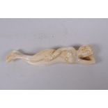 A sectional carved bone figure of a reclining female nude, 12cm long