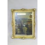 A gilt composition wall mirror with swept frame, 63 x 79cm