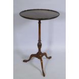 A mahogany wine table on a turned column and tripod supports, the dish top with an engraved circular