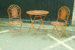 A painted metal folding bistro table and two chairs, table AF