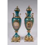 A pair of Sevres style porcelain urns and covers with ormolu mounts and handles, with decorative
