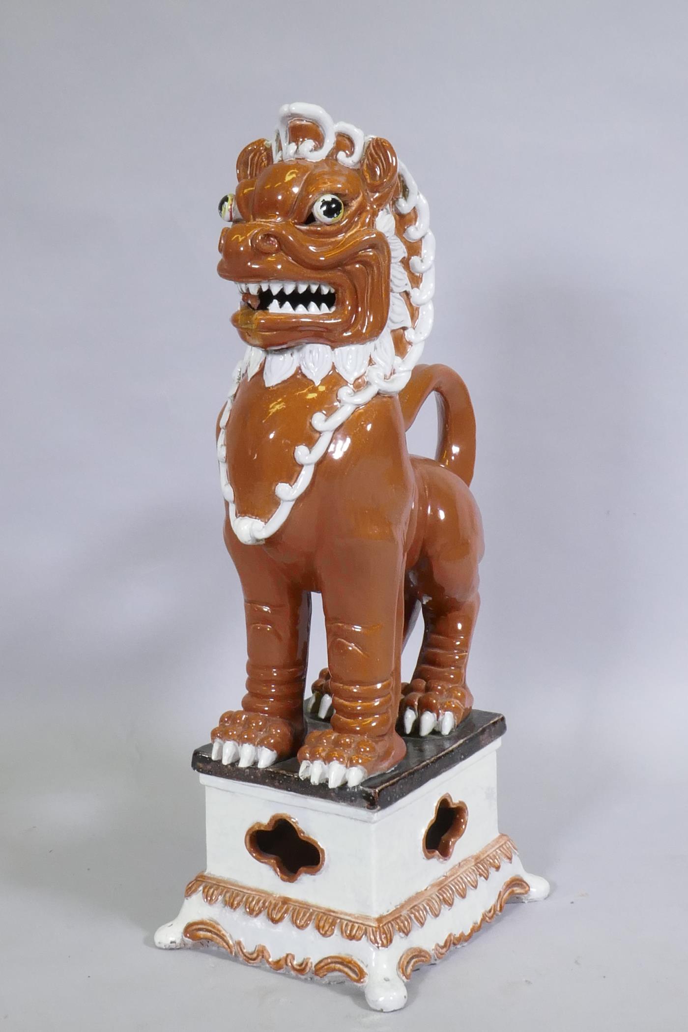 An Oriental painted and glazed terracotta figure of a temple lion, 78cm high