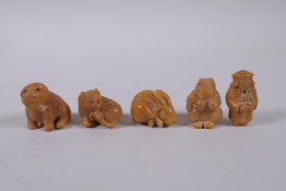Five Japanese carved tagua nut netsuke in the form of rabbits, a tiger, dog and a sage, largest 4cm