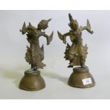 A pair of Siamese bronze dancing figures, with inset glass eyes, and mirrored glass decoration, 29cm