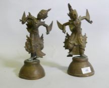 A pair of Siamese bronze dancing figures, with inset glass eyes, and mirrored glass decoration, 29cm