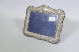 A hallmarked silver photograph frame with repousse decoration, rebate 18 x 13cm