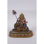 A Sino Tibetan cold painted bronze of a wrathful deity seated on a the back of a kylin, 4