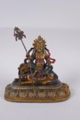 A Sino Tibetan cold painted bronze of a wrathful deity seated on a the back of a kylin, 4