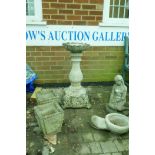 A reconstituted stone birdbath, 82cm high, a pair of planters and two garden figures
