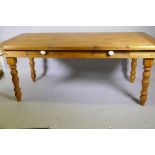 A pine farmhouse style table with two drawers, raised on turned supports, 90 x 180 x 76cm, legs