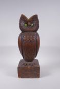 An antique Black Forest style carved oak owl with inset glass eyes, 42cm high