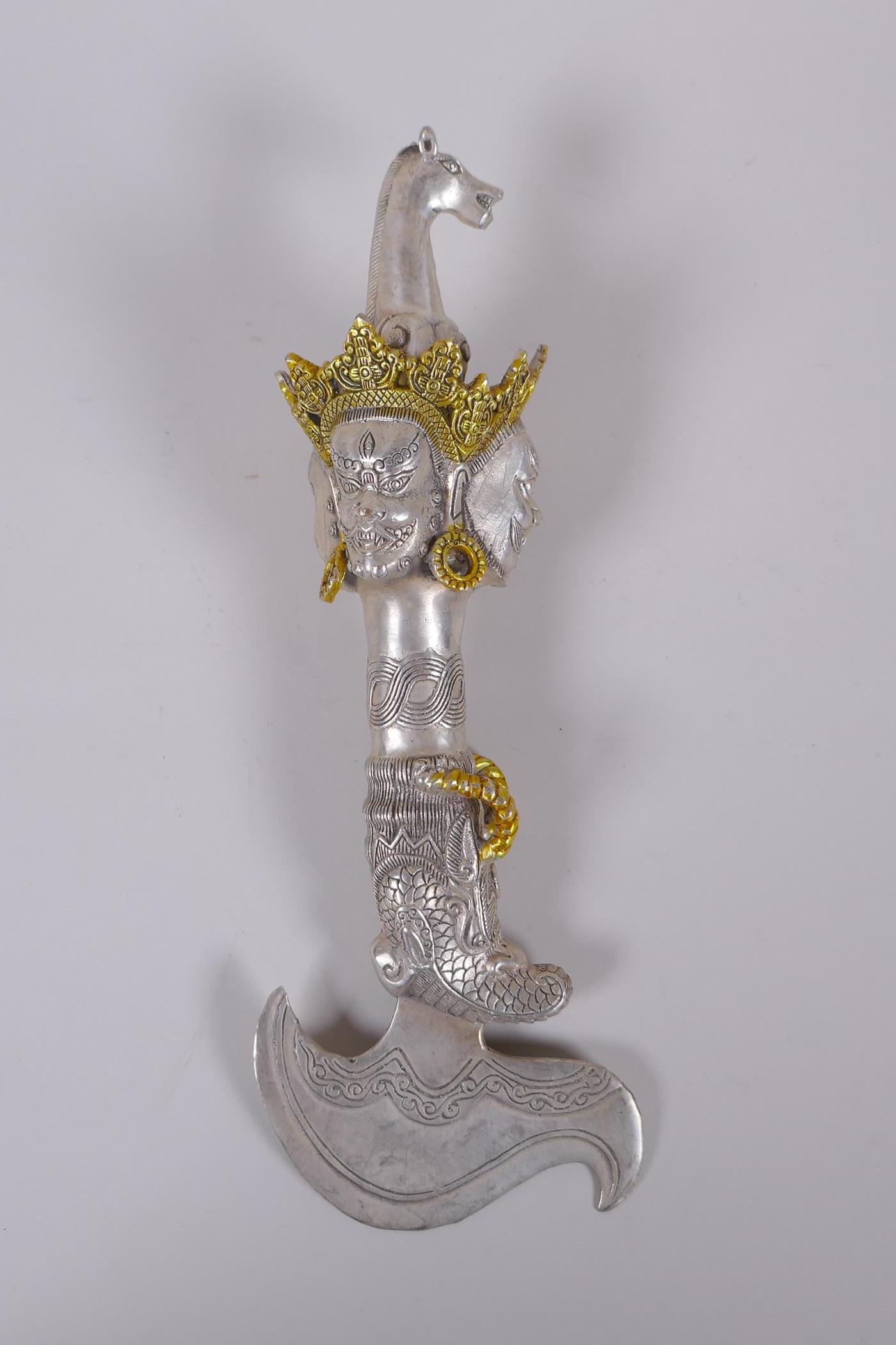 A Tibetan white metal kartika, the handle decorated with wrathful deity masks, 27cm