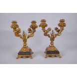 A pair of ormolu two branch candlesticks, decorated with fish tailed putti, 27cm high