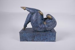 A contemporary patinated bronze sculpture of a stylised reclining female nude, 26cm long