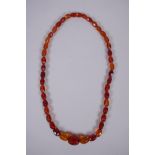A graduated and faceted honey amber bead necklace, 51cm long, clasp AF