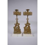 A pair of antique ormolu and marble candlesticks decorated with two girls and a deer, 36cm high