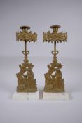 A pair of antique ormolu and marble candlesticks decorated with two girls and a deer, 36cm high