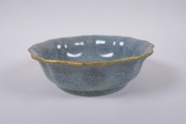 A Chinese celadon Ge-ware dish of lobed form with a gilt metal rim and chased character marks to