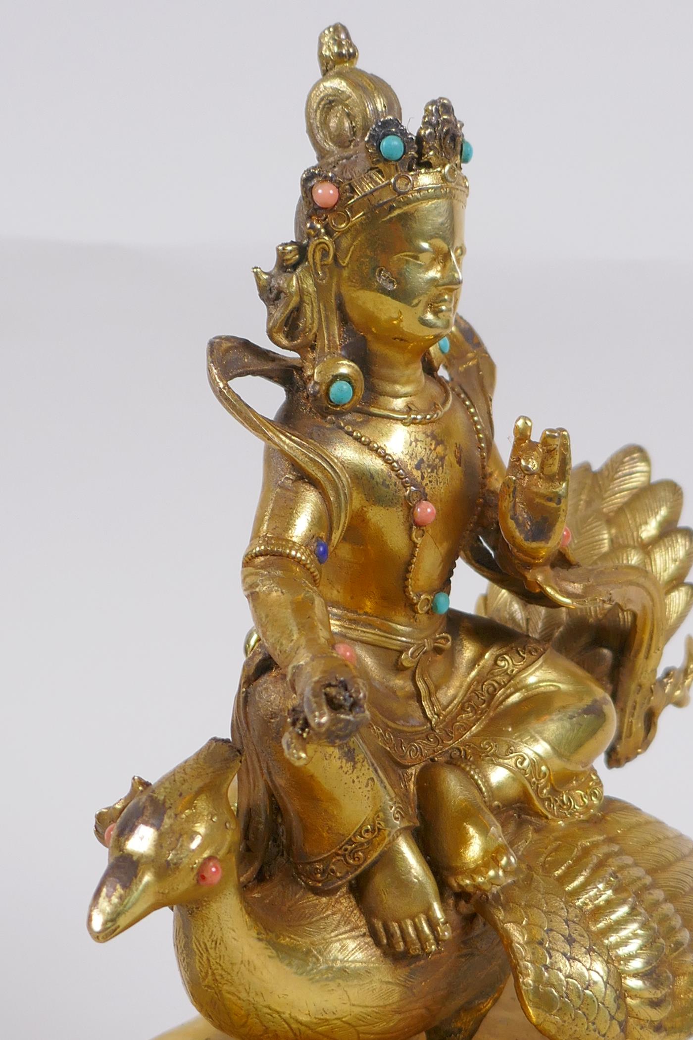 A Sino Tibetan gilt bronze figure of Buddha seated on the back of a phoenix, with inset coral, - Image 3 of 6