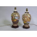 A pair of oriental ceramic table lamps mounted on carved wood bases, 34cm high