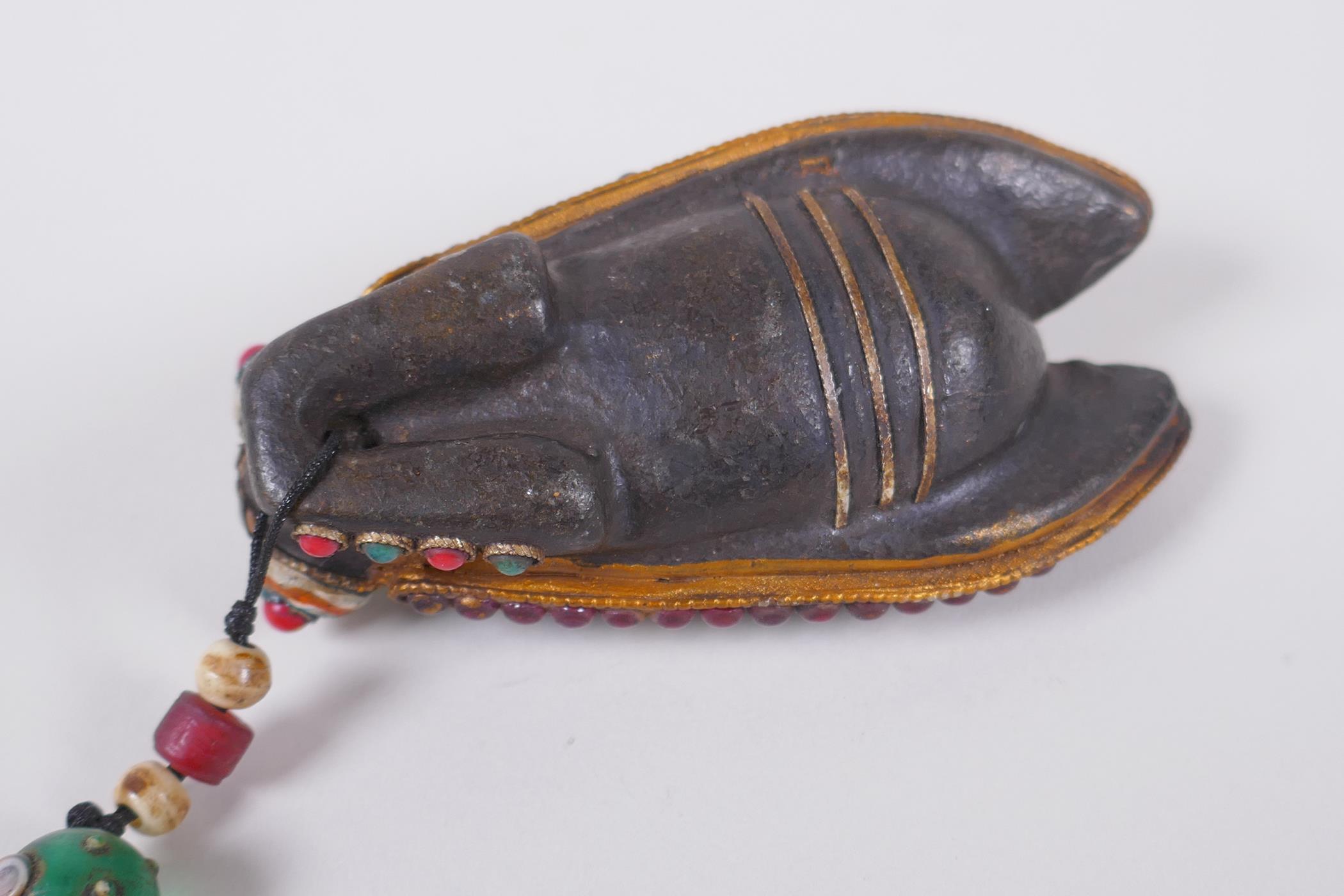 A Tibetan iron toggle in the form of a cicada, the wings set with a dzi bead, abalone, coral and - Image 3 of 3