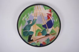 A Soviet style porcelain cabinet plate decorated with a soldier and girl on a swing, 27cm diameter