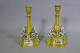 A pair of Sevres style ceramic candlesticks with Empire style decoration, 31cm high