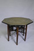 An antique Indo Persian octagonal brass tray table with repousse elephant and bird decoration,