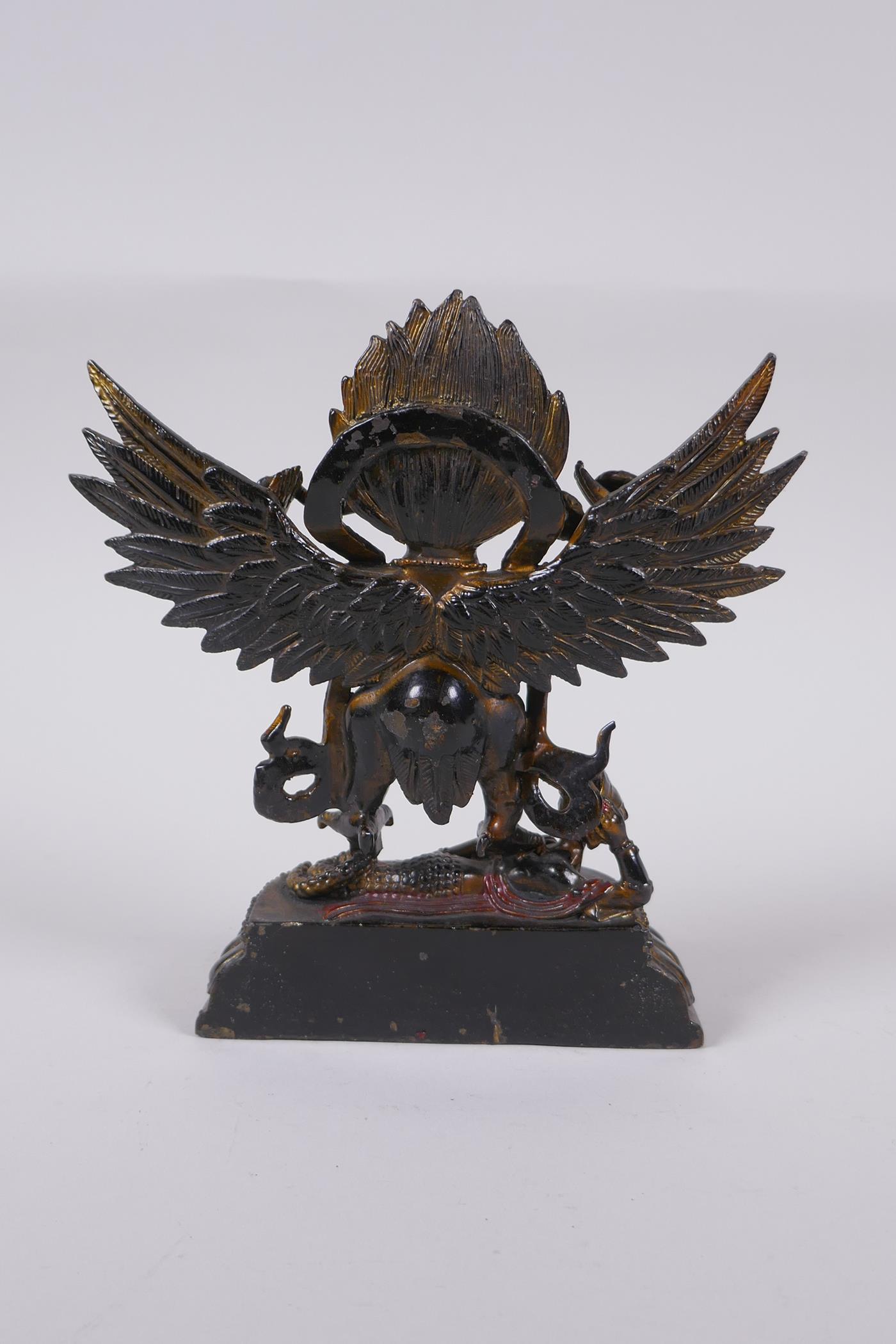 A Tibetan lacquered and gilt bronze of Garuda standing on the back of a figure, 17cm high - Image 5 of 6