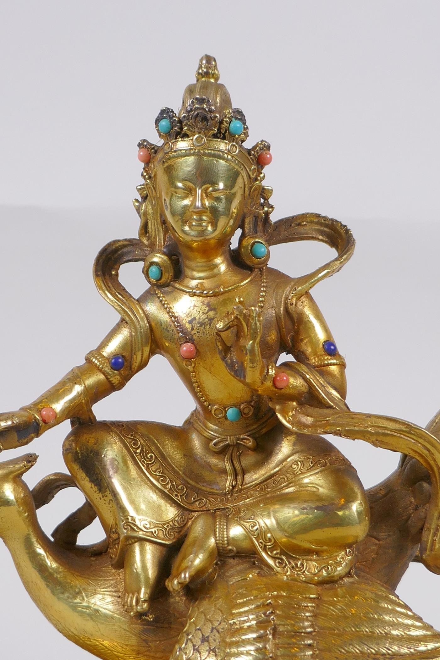 A Sino Tibetan gilt bronze figure of Buddha seated on the back of a phoenix, with inset coral, - Image 2 of 6