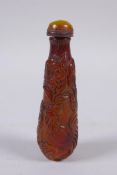 A Chinese faux amber snuff bottle with chicken decoration, 9cm