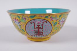 A Chinese polychrome porcelain bowl decorated with auspicious symbols and flowers, character