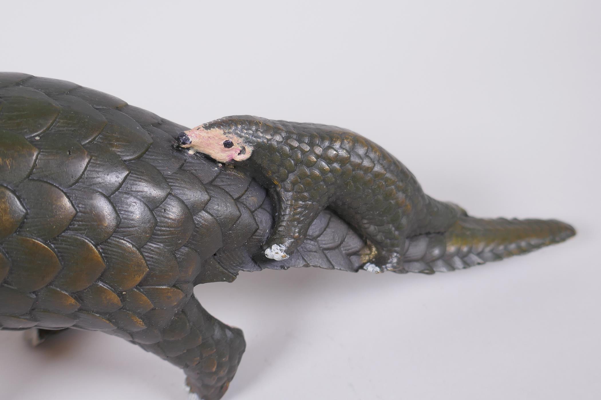 A cold painted filled bronze figure of a pangolin with a pup riding on its back, 32cm long - Image 3 of 5