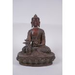 A Tibetan bronzed metal Buddha with the remnants of gilt and copper patina, impressed double vajra