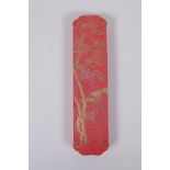 A Chinese red ground ink stone with gilt relief landscape and dragon decoration, in a fitted box,