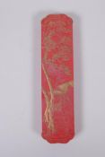 A Chinese red ground ink stone with gilt relief landscape and dragon decoration, in a fitted box,