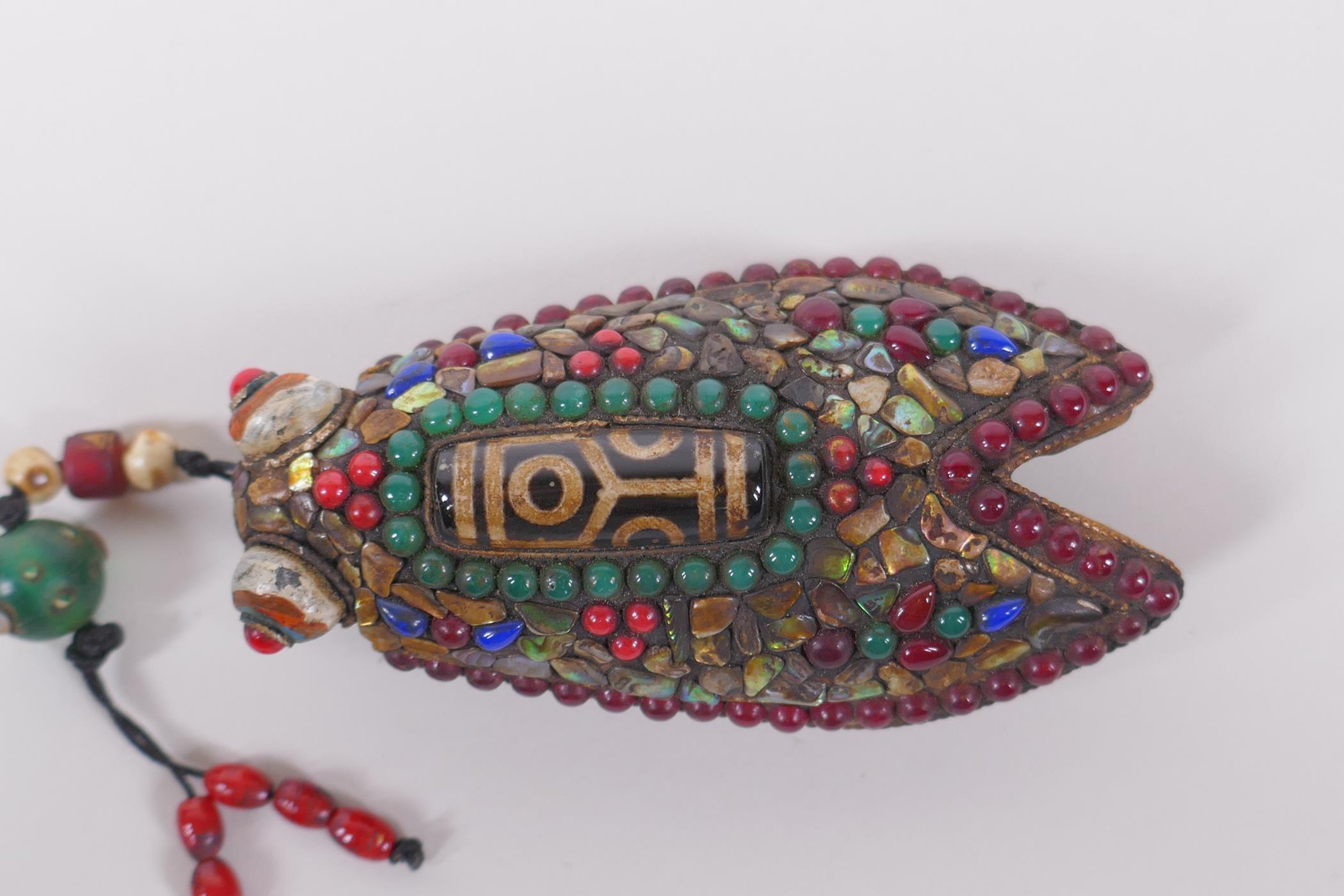 A Tibetan iron toggle in the form of a cicada, the wings set with a dzi bead, abalone, coral and - Image 2 of 3