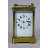A large brass carriage clock, the enamel dial with Roman numerals, the French movement striking on a