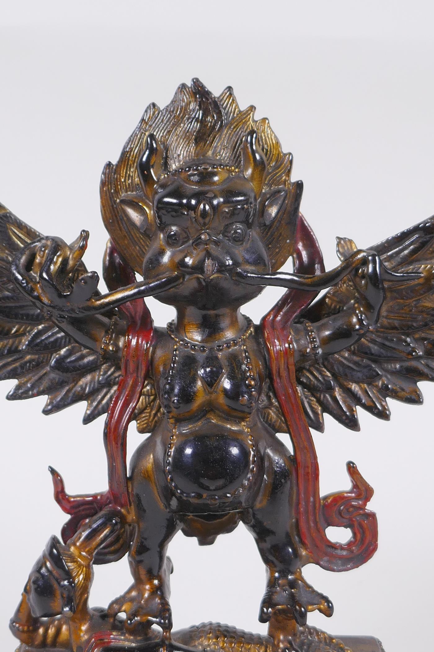 A Tibetan lacquered and gilt bronze of Garuda standing on the back of a figure, 17cm high - Image 2 of 6