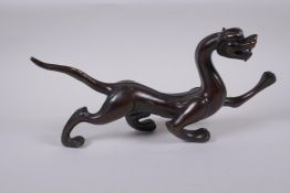 A Chinese stylised bronze figure of a dragon, 32cm long