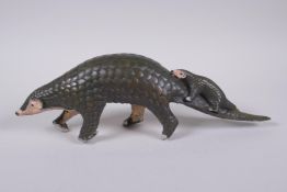 A cold painted filled bronze figure of a pangolin with a pup riding on its back, 32cm long