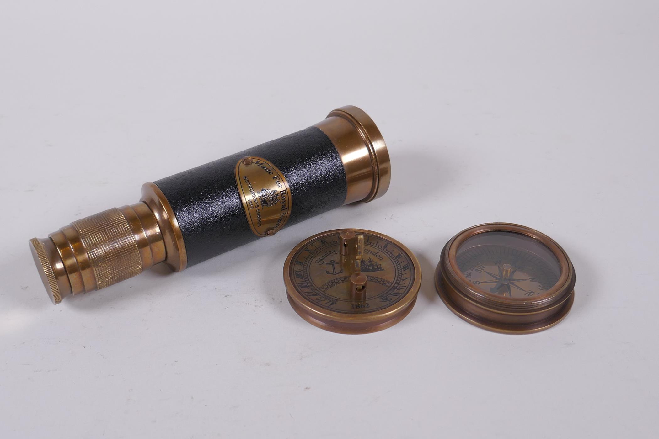 A reproduction brass sundial compass and a brass and leatherette miniature telescope, 13cm long