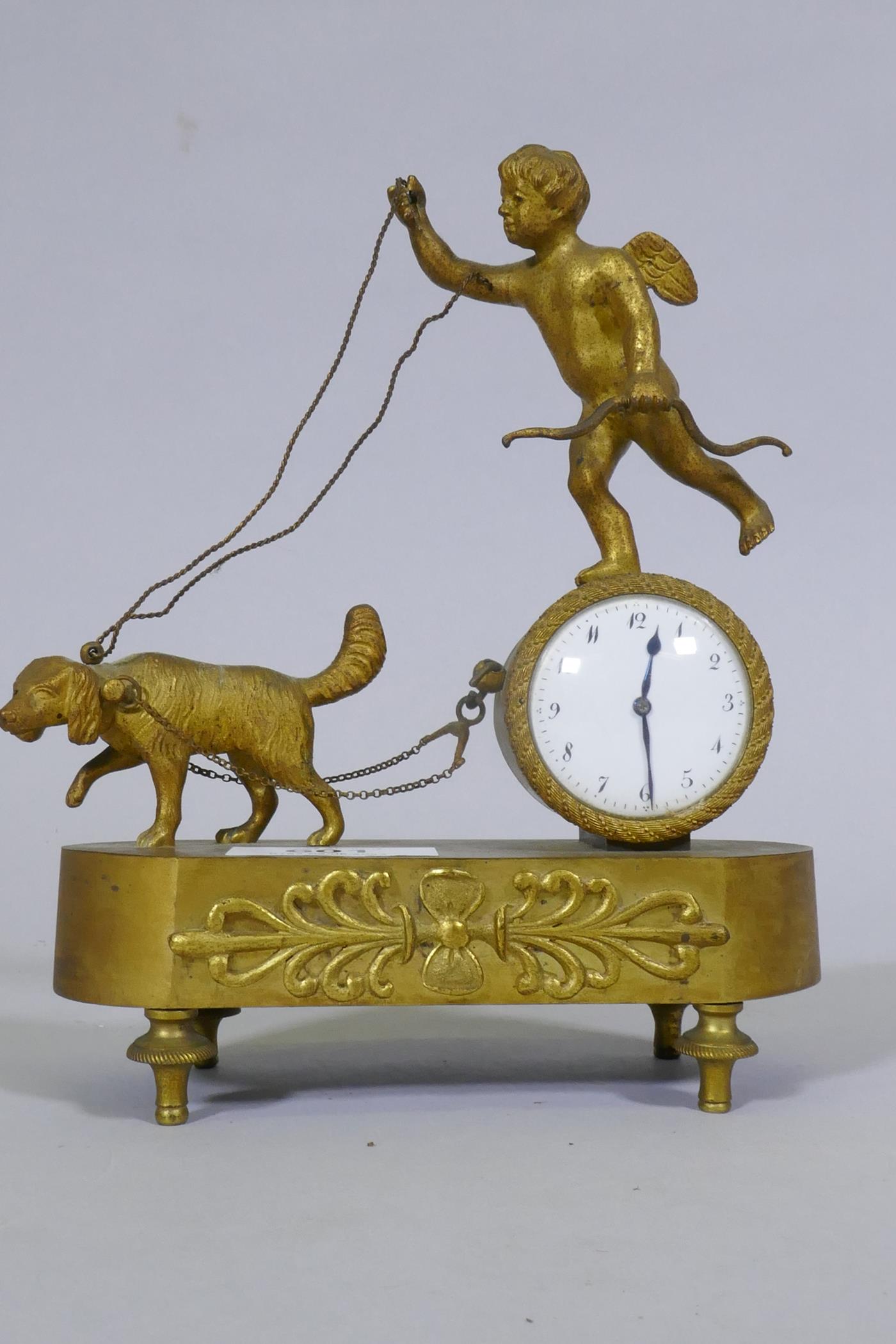 A C19th French Empire Style ormolu mantel clock, with putto and dog, and anthemion decoration,