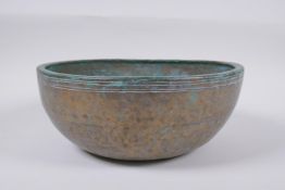 A C19th Tibetan hammered silvered bronze singing bowl, 27cm diameter a/f