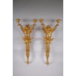 A pair of ormolu two branch wall sconces in the form of a winged putti, 70cm x 30cm wide