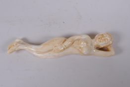 A sectional carved bone figure of a reclining female nude, 12cm long